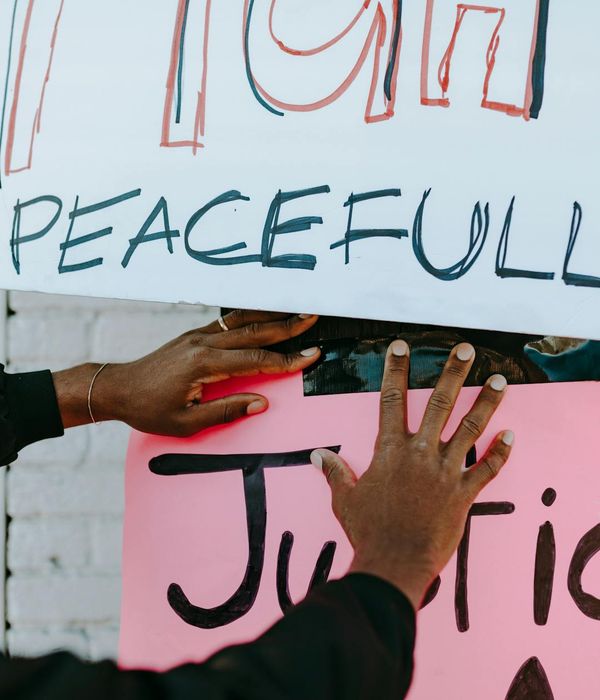 Person meditating peacefully in a serene, dark environment with cyan light.